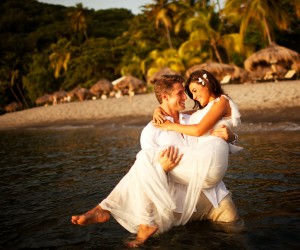 Quando falamos de Destination Wedding, Santa Lúcia é o destino perfeito para casais que buscam uma opção única, sofisticada e original para uma cerimônia de casamento diferente ou uma lua-de-mel memorável e ultrarromântica. Nenhuma outra ilha caribenha é tão dedicada aos casais em lua-de-mel, ao romance, às festas de casamento e à renovação dos votos de seus visitantes como Santa Lúcia. E quem opta por vivenciar esses momentos em Santa Lucia tem à sua disposição o melhor de tudo: das locações à gastronomia premiada, da decoração ao buquê da noiva e à contagiante música ao vivo. Não à toa, a ilha já foi eleita por sete vezes a “World's Leading Honeymoon Destination” e a “Caribbean's Leading Honeymoon Destination”. É por isso que alguns dos maiores wedding planners do mundo, como os novaiorquinos David Beahm e Alan Berg, sempre indicam Santa Lúcia aos seus clientes. E, a propósito, no mês passado eles participaram de um Simpósio de Casamentos promovido na ilha, reunindo experts dos cinco continentes. Todos os principais hotéis da ilha oferecem pacotes para noivos buscando um lugar para um casamento de sonhos ou para uma lua de mel inesquecível. No Jade Mountain, resort de luxo que pertence ao russo Nick Troubetzkoy, os noivos podem armar sua celebração no Terraço Celestial, no alto do hotel, nas areias da praia particular do hotel (com direito a queima de fogos de artifício), ao lado de uma linda cachoeira ou mesmo a bordo de um barco. A cerimônia pode ser transmitida em tempo real via internet para o mundo todo, para que aqueles amigos e/ou familiares que não puderam viajar também a Santa Lúcia sigam tudo o que acontece por lá. Para a lua-de-mel, as suítes do Jade Mountain - que lá são chamadas de "santuários" - são o melhor lugar do mundo: todas têm piscina privativa com borda infinita, solarium, hidromassagem, cama com dossel, mordomo exclusivo e uma vista de tirar o fôlego para as montanhas Piton, que são o principal cartão-postal da ilha. Os noivos podem ainda agendar aulas de yoga, massagens e jantares no quarto – ou melhor, em seus santuários! Para eternizar esses momentos, um fotógrafo especial pode fazer uma sessão de fotos que depois é editada num luxuoso álbum. Alguns desses itens saem de graça para os casais que se hospedam por lá por pelo menos cinco noites. As diárias começam em US$ 1.450 (na baixa temporada, de junho a outubro) e US$ 1.600 (na alta temporada). Quem optar por casar no Boucan Hotel Chocolat, um refúgio eco-chic instalado em meio a uma plantação de cacau - pode promover a chamada Hotel Takeover, em que os noivos e seus convidados ocupam todos os 14 quartos por um mínimo de três noites. Há vários espaços que podem ser utilizados como cenário para a cerimônia de casamento: no restaurante onde até os drinques são feitos à base de cacau, com vista para a imponente montanha rochosa de Petit Piton, à beira da piscina, no pátio central ou em qualquer outro lugar dentro da propriedade de 140 mil m². O spa pode ser convertido em um grande salão de beleza onde a noiva e suas madrinhas e amigas se preparam para o grande momento com a ajuda de cabeleireiras e esteticistas. O pacote inclui a decoração da festa, o banquete com pratos elaborados com cacau, rum, baunilha e outros ingredientes locais, o buquê da noiva, a orquídea para a lapela do noivo, o bolo, um cinegrafista e um passeio de lancha para o casal no dia seguinte. Se os noivos em lua-de-mel preferirem se hospedar no elegante Viceroy Sugar Beach, na linda baía de Anse Piton, eles podem optar pelo pacote Just Married, que inclui decoração especial no quarto com flores tropicais, café da manhã no quarto, massagem para o casal e um passeio de lancha ao pôr do sol, com direito a champanhe para aquele brinde memorável. Por fim, no Sandals Grande Lucian, os recém-casados que buscam momentos a dois vão encontrar muita privacidade e conforto nos Love Nests, vilas que são - como o nome diz - verdadeiros ninhos de amor, com um atencioso e discreto mordomo pessoal, piscina privativa, solarium, lençóis de algodão egípcio bordados a mão e amplos banheiros com hidromassagem e confortáveis roupões atoalhados. Casais que ficam mais de três noites no hotel ganham US$ 500 de bônus para promover seu casamento – o hotel tem vários pacotes de cerimônia pré-formatados à escolha dos noivos. Seja qual for o hotel escolhido, Santa Lúcia é uma das mais românticas e mágicas ilhas do planeta, perfeita para um casamento, uma lua-de-mel ou uma escapada romântica, com uma gastronomia rica, exótica e cheia de sabor, seus elegantes hotéis de frente para o mar, seus spas com incríveis tratamentos para o relax dos visitantes e suas praias de uma beleza sem igual. E ela não é uma “ilha shopping center”, com hordas de turistas e praias lotadas; é sim uma “ilha boutique”, pequenina, charmosa e exclusiva. Para chegar a Santa Lúcia, as companhias aéreas Delta, American Airlines e JetBlue operam voos diários, partindo de cidades como Miami, Atlanta e Nova York.